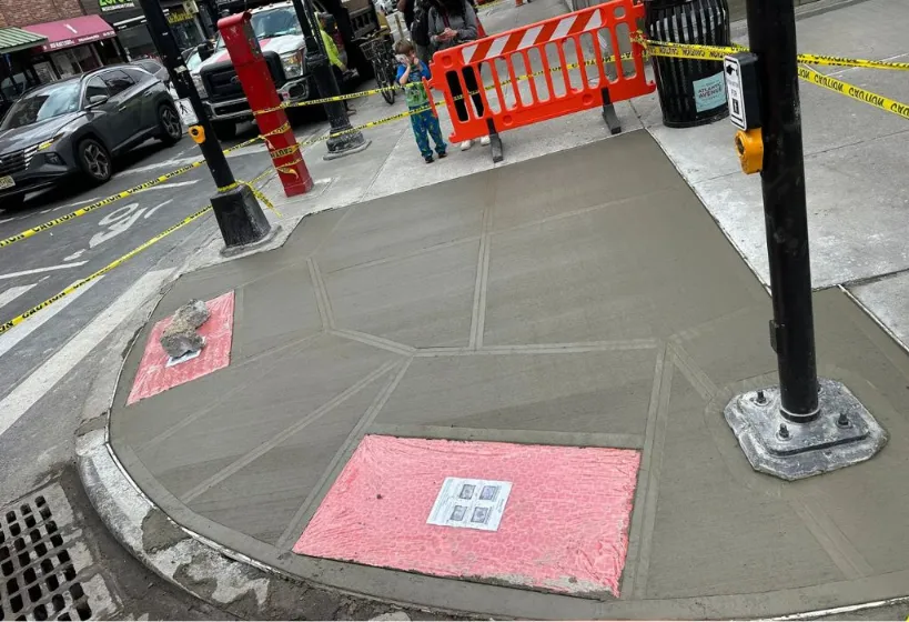 Concrete sidewalk in Manhattan, featuring a sleek and sturdy design seamlessly integrated into the urban environment.